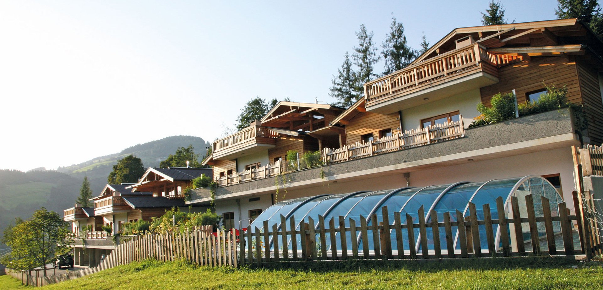 Außenansicht Alpin Chalets XL mit Gemeinschaftspool in Wagrain im Sommer.